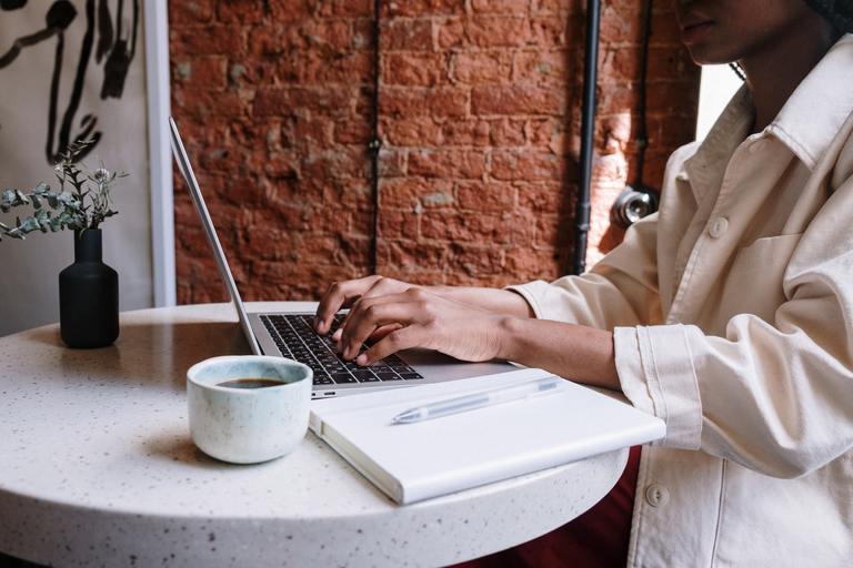 Donna che utilizza un computer portatile in un caffè