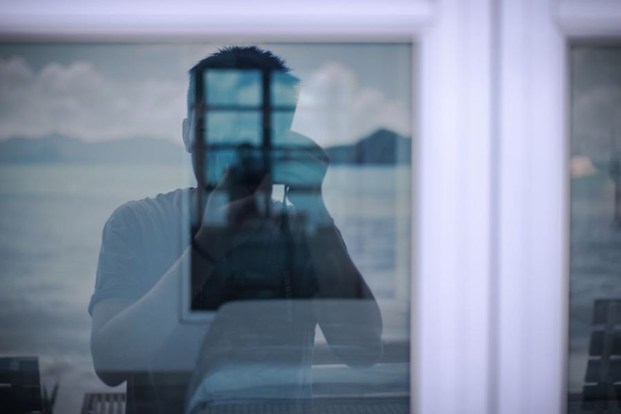 窓の写真を撮る男性